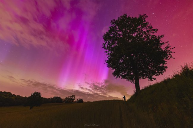 NASA Astronomy Photo of the Day by Mariusz Durlej. A red and rayed aurora was captured in a single 6-second exposure from Racibórz, Poland, during this weekend's intense solar storm. Northern lights don't usually reach so far south. The photographer's friend, seeing an aurora for the first time, is visible in the distance also taking images of the beautifully colorful nighttime sky. From NASA's Astronomy Picture of the Day.